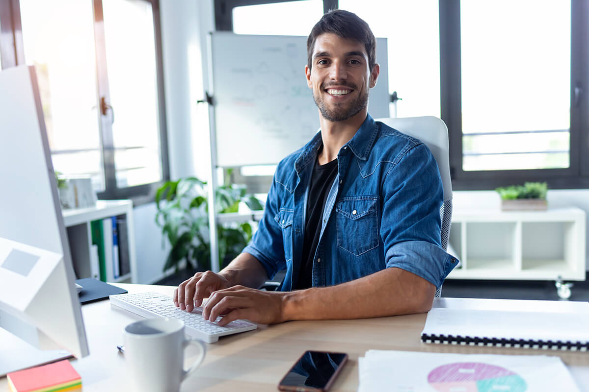 software-developer-looking-at-camera-while-working-GHAS7B2.jpg